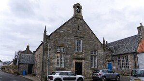 A stone building with a traditional architectural style, featuring a prominent tower and a bell. - Stunning spacious apt in culross (culross, fife)