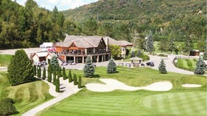 Camp de golf amb un club, sorrals i una bassa.