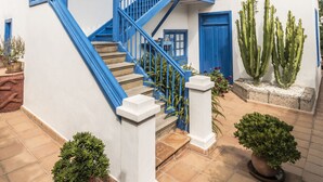 A two-story building with blue trim and a staircase leading to the upper floor.