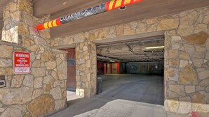A stone-walled parking garage entrance with a warning sign about parking violations. - Fabulous Ski In and Ski Out Condo at Grand Timber Lodge in Breckenridge, CO (Breckenridge)
