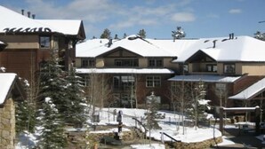 A large, multi-story building with snow-covered roofs and a stone facade. - Fabulous Ski In and Ski Out Condo at Grand Timber Lodge in Breckenridge, CO (Breckenridge)