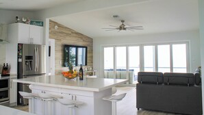 Una cocina moderna con una isla grande, electrodomésticos de acero inoxidable y vistas al exterior.