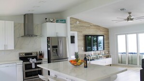 Una cocina moderna con electrodomésticos de acero inoxidable, una isla grande con frutero y vistas al exterior.