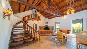 Eine Holztreppe mit Kamin aus Stein und einem Essbereich mit Holzmöbeln.