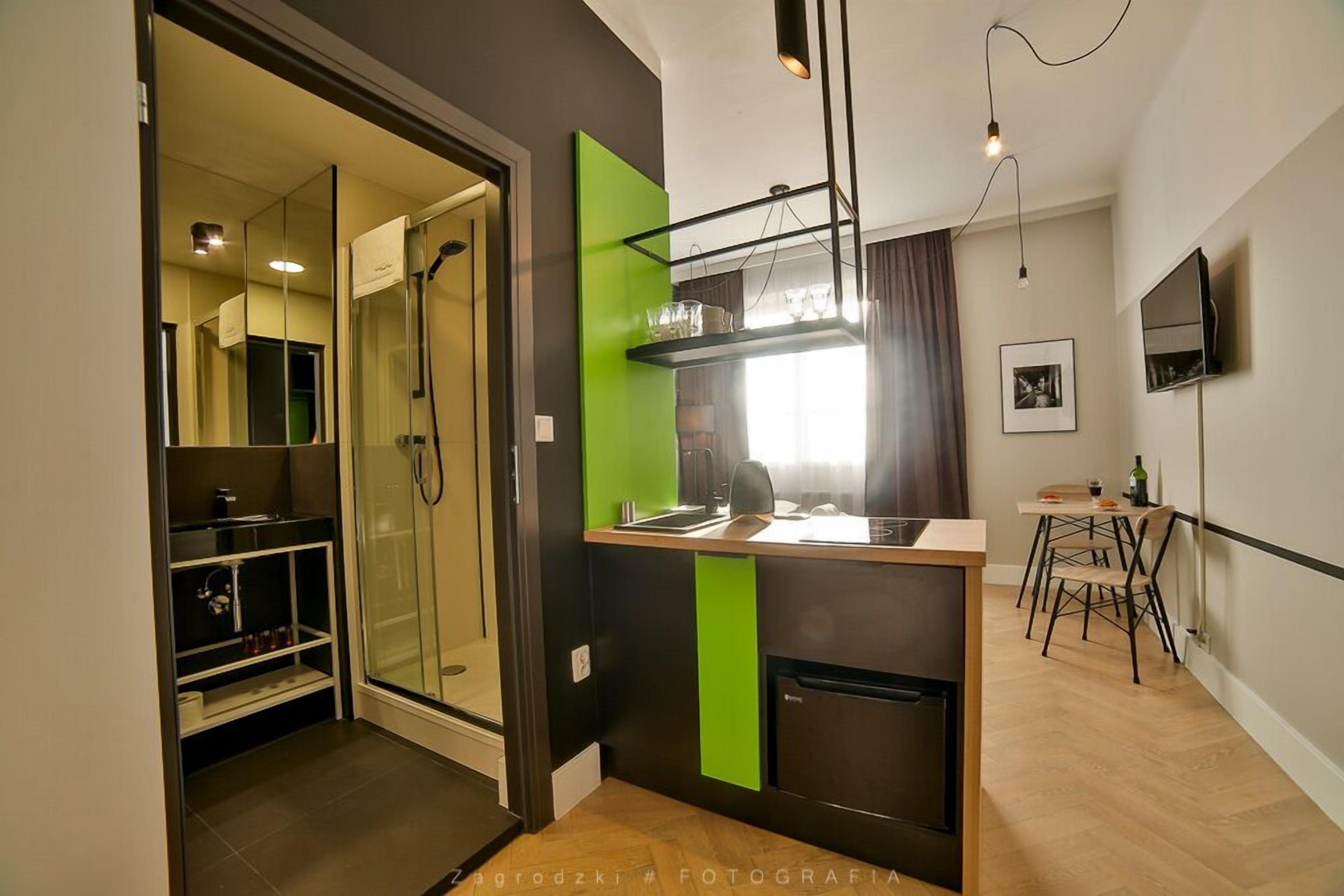 A compact kitchen with a sink, a coffee machine, and a small refrigerator.