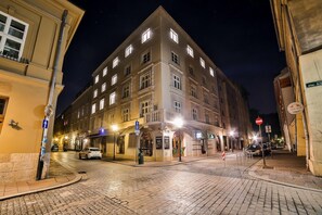 A historic building with multiple floors and a corner entrance, featuring a ground-floor shop and a visible entrance with a sign. - Saint Thomas Corner (Kraków)