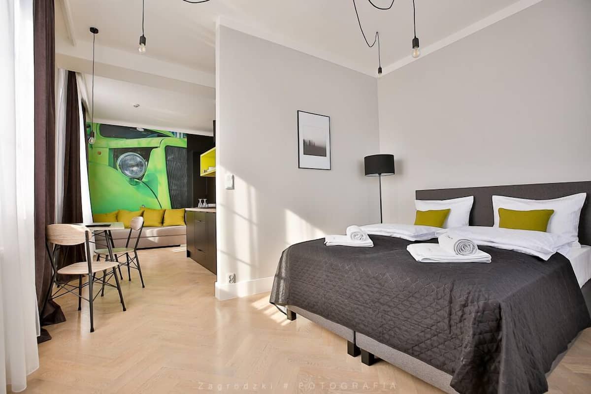Una habitación de hotel moderna con una cama grande, un escritorio y una silla.