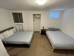 A bedroom with two beds, a closet, a nightstand, and a window. - Entire 4 Bedroom Home with easy access (Edmonton)