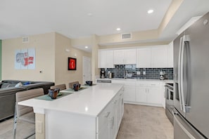 Enjoy cooking in this well-equipped kitchen with a central island, white cabinetry, and stainless steel appliances.