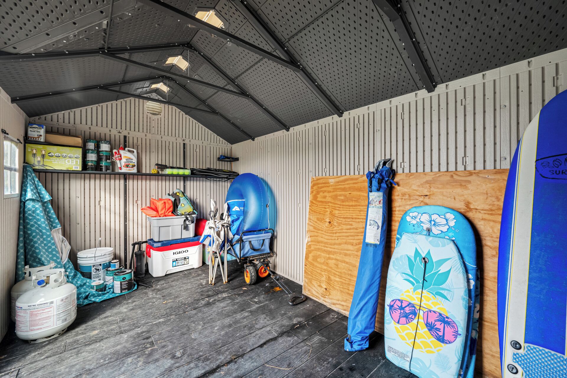 En garage med arbejdsbord, værktøj og surfbrædder.