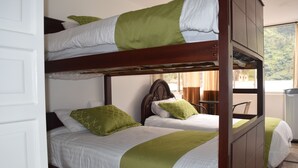 A bunk bed room with two beds, each with green and white bedding.