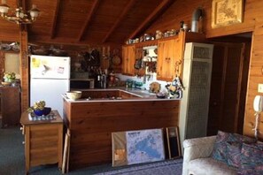 Kitchen with central island, refrigerator, and storage for kitchen essentials.