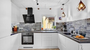 A modern kitchen with a built-in oven, a window, and a view of the outside. - Stunning home in Sjællands Odde (Sjællands Odde)