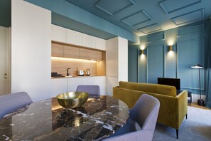 A modern dining area with a marble table, gold bowl, and contemporary furniture.