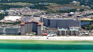 Un complexe hôtelier situé sur la côte, composé de plusieurs immeubles de grande hauteur, donnant sur la plage et disposant d’un vaste parking.