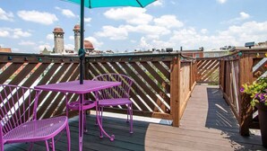 A wooden deck with a turquoise umbrella, two purple metal chairs, and a table. - Artistic Abode Close to MICA & Johns Hopkins (Baltimore)