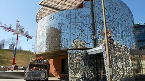 A building with a unique mosaic exterior, a covered entrance, and a decorative truck in front. - Artistic Abode Close to MICA & Johns Hopkins (Baltimore)