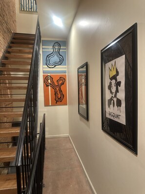 Un escalier avec une rampe noire menant à un palier.