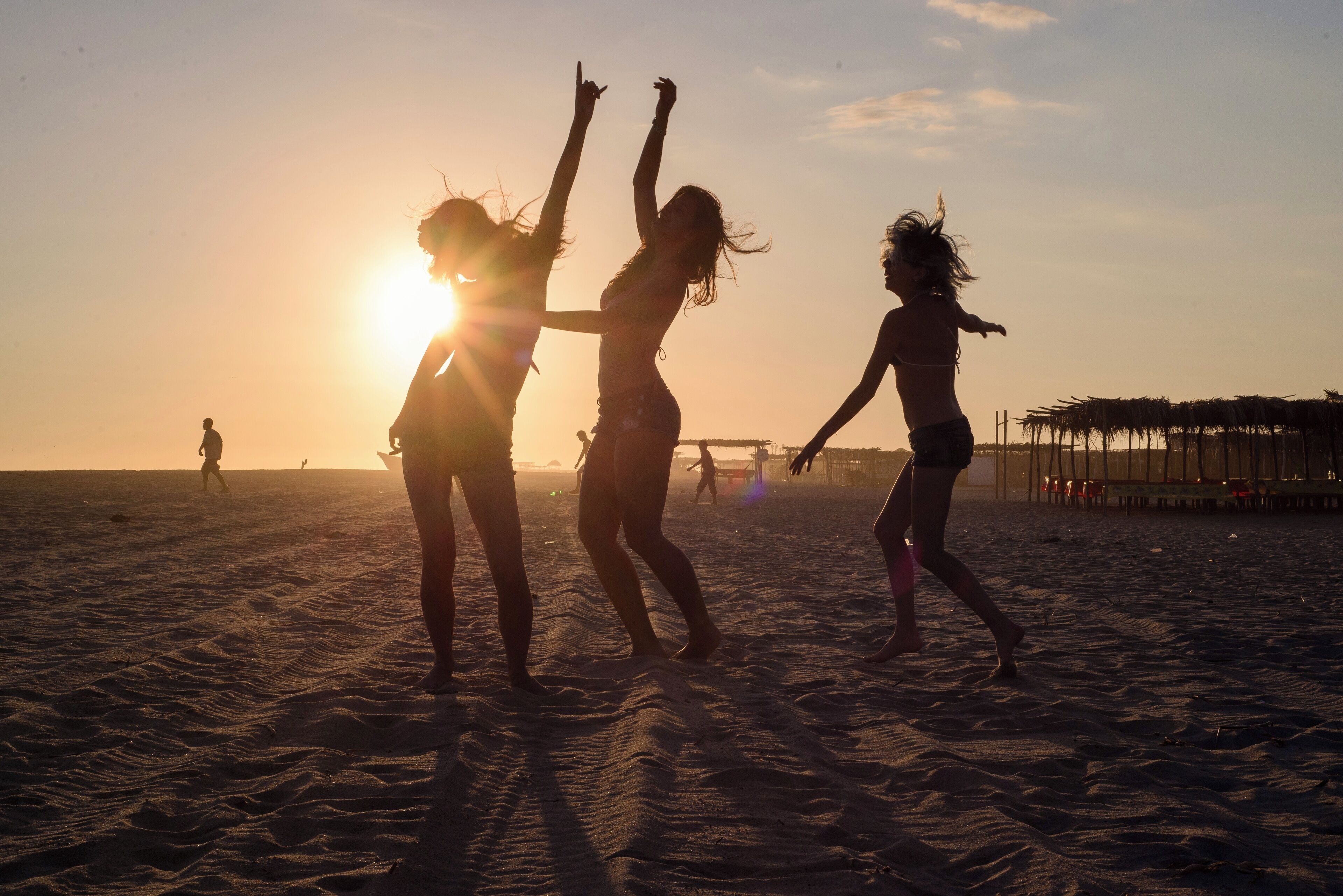 Une scène de plage où des personnes profitent du coucher de soleil.