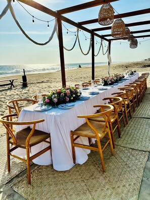 A beachside dining setup with tables and chairs, overlooking the ocean. - Hotel Boutique Punta Jamaica (Coyuca de Benitez)