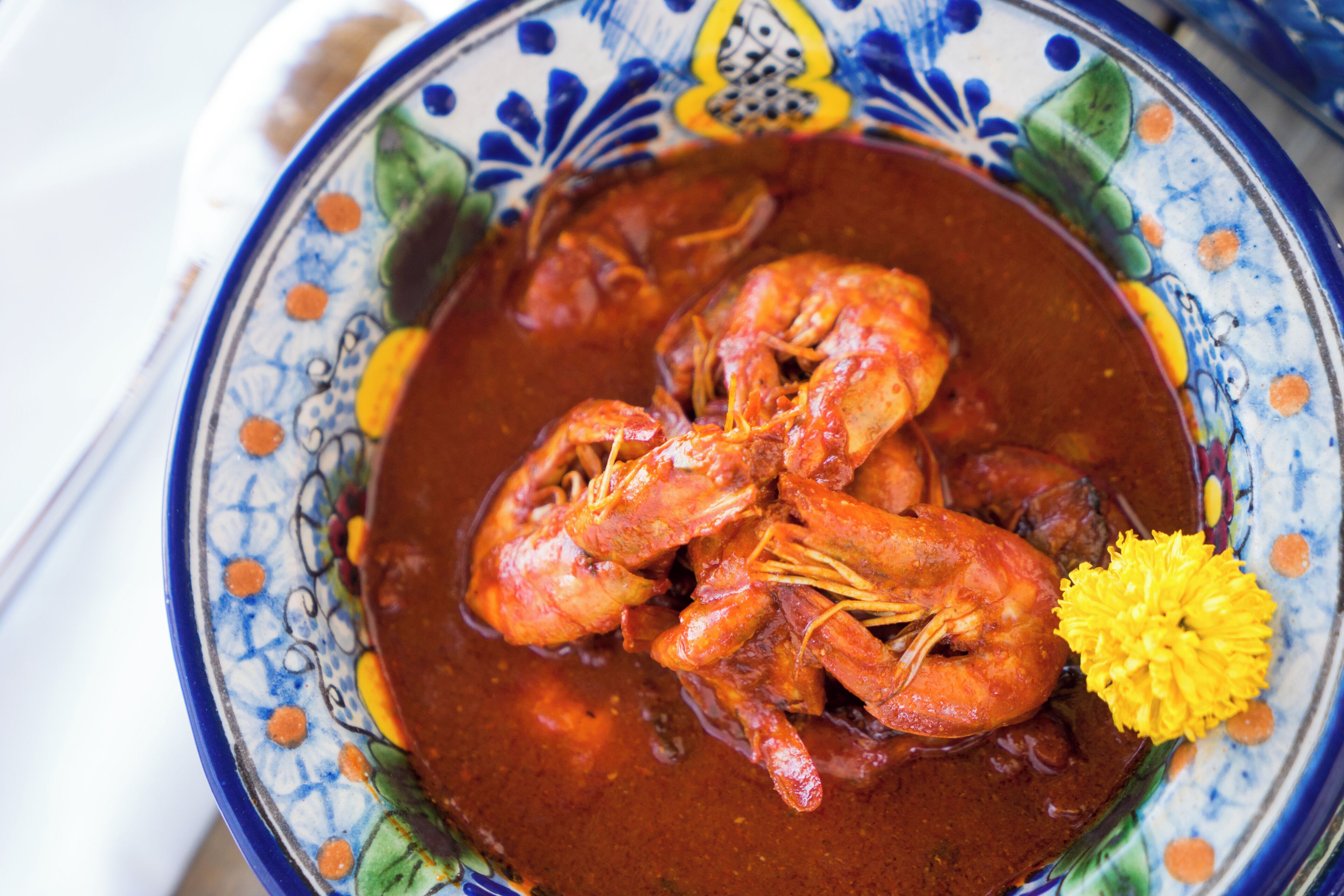 Un bol de curry aux crevettes, décoré d’une fleur.