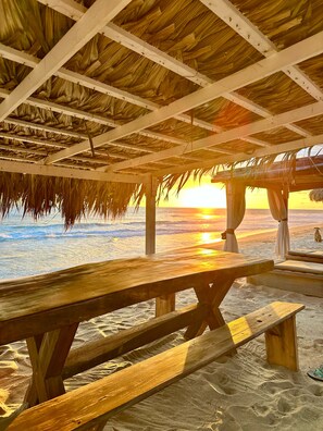 A beachside wooden structure with a thatched roof overlooking the ocean at sunset. - Hotel Boutique Punta Jamaica (Coyuca de Benitez)