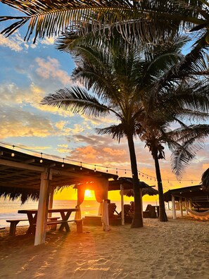 A beachside pavilion with a sunset view, palm trees, and a thatched-roof structure. - Hotel Boutique Punta Jamaica (Coyuca de Benitez)