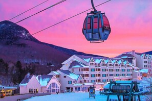 A ski lift with a cable car moving over a snowy landscape. - Loon Escape (Lincoln)