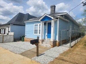 A single-story house with a blue door, numbered 569, and a mailbox.