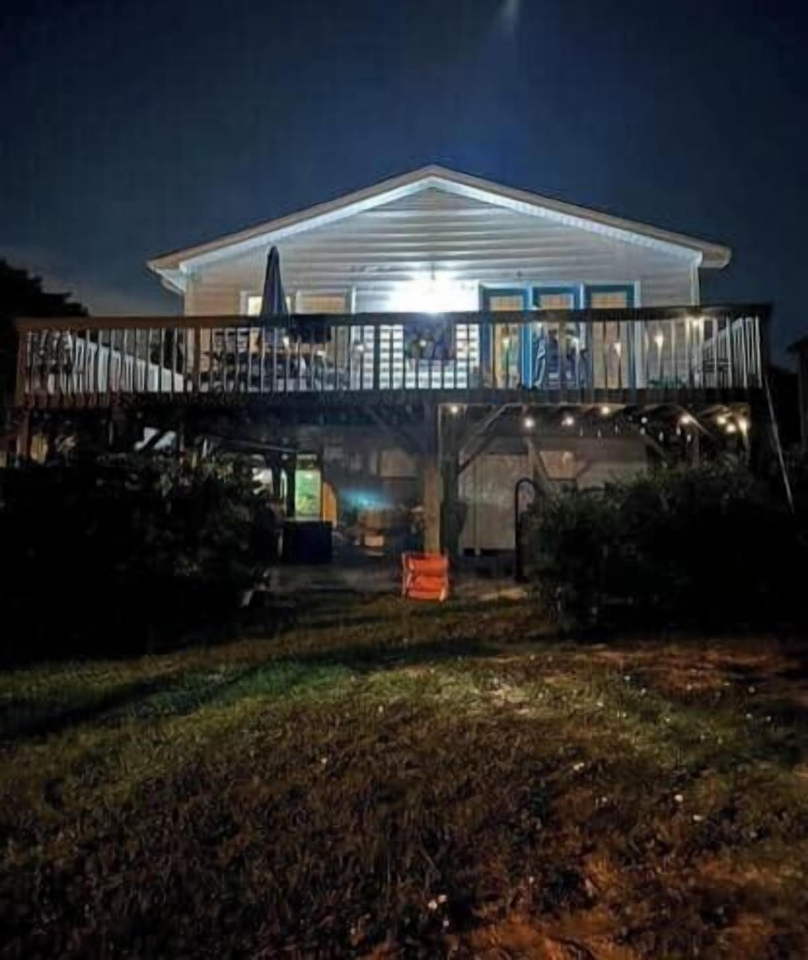A two-story house with a balcony, a garage, and a well-lit front porch.