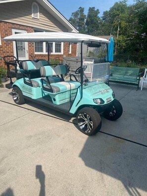 Um carrinho de golfe estacionado na entrada da propriedade.