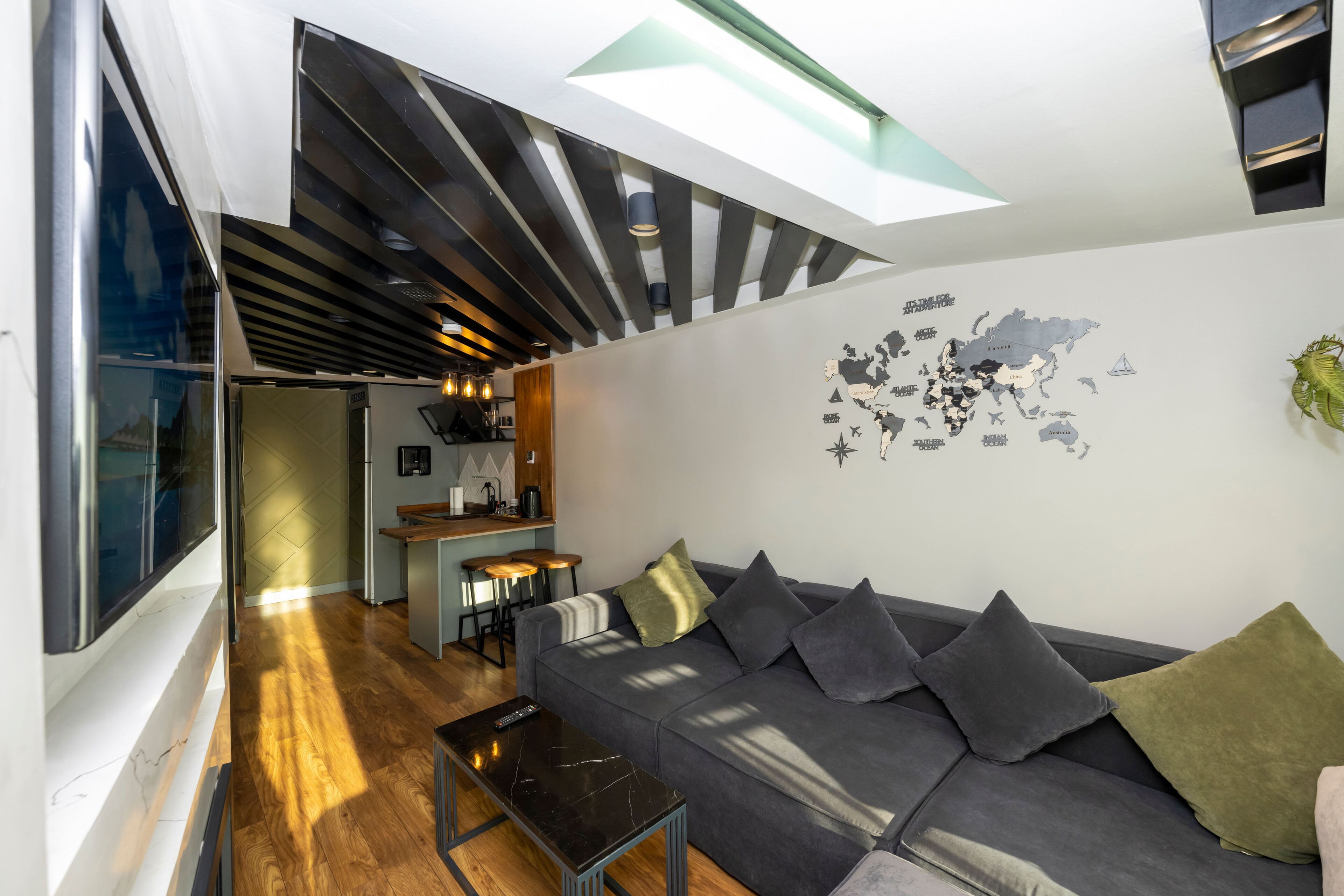 A modern living room with a sofa, coffee table, and a map on the wall.