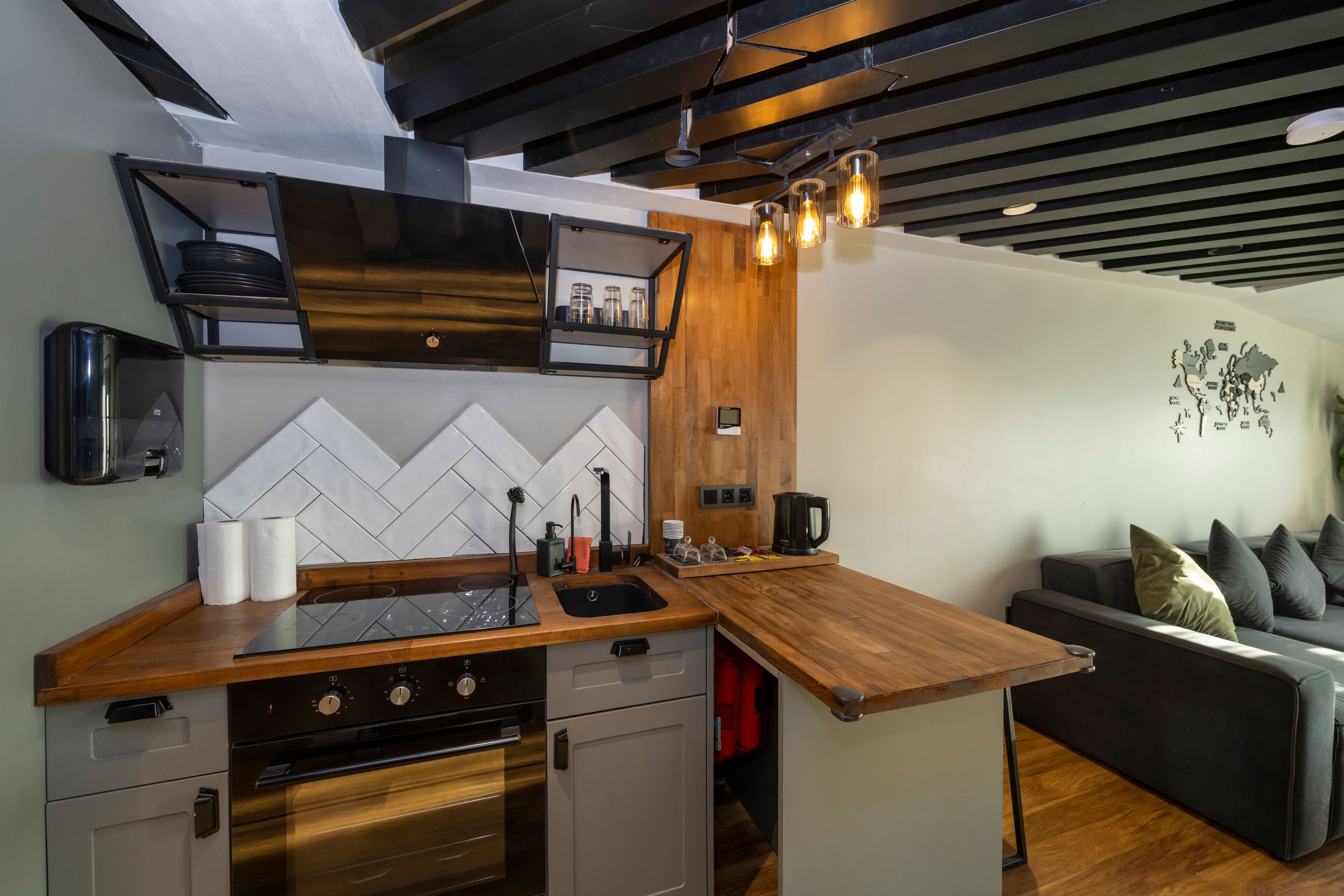 A modern kitchen with a wooden countertop, built-in oven, and a black range hood.