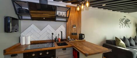 A modern kitchen with a wooden countertop, built-in oven, and a black range hood.