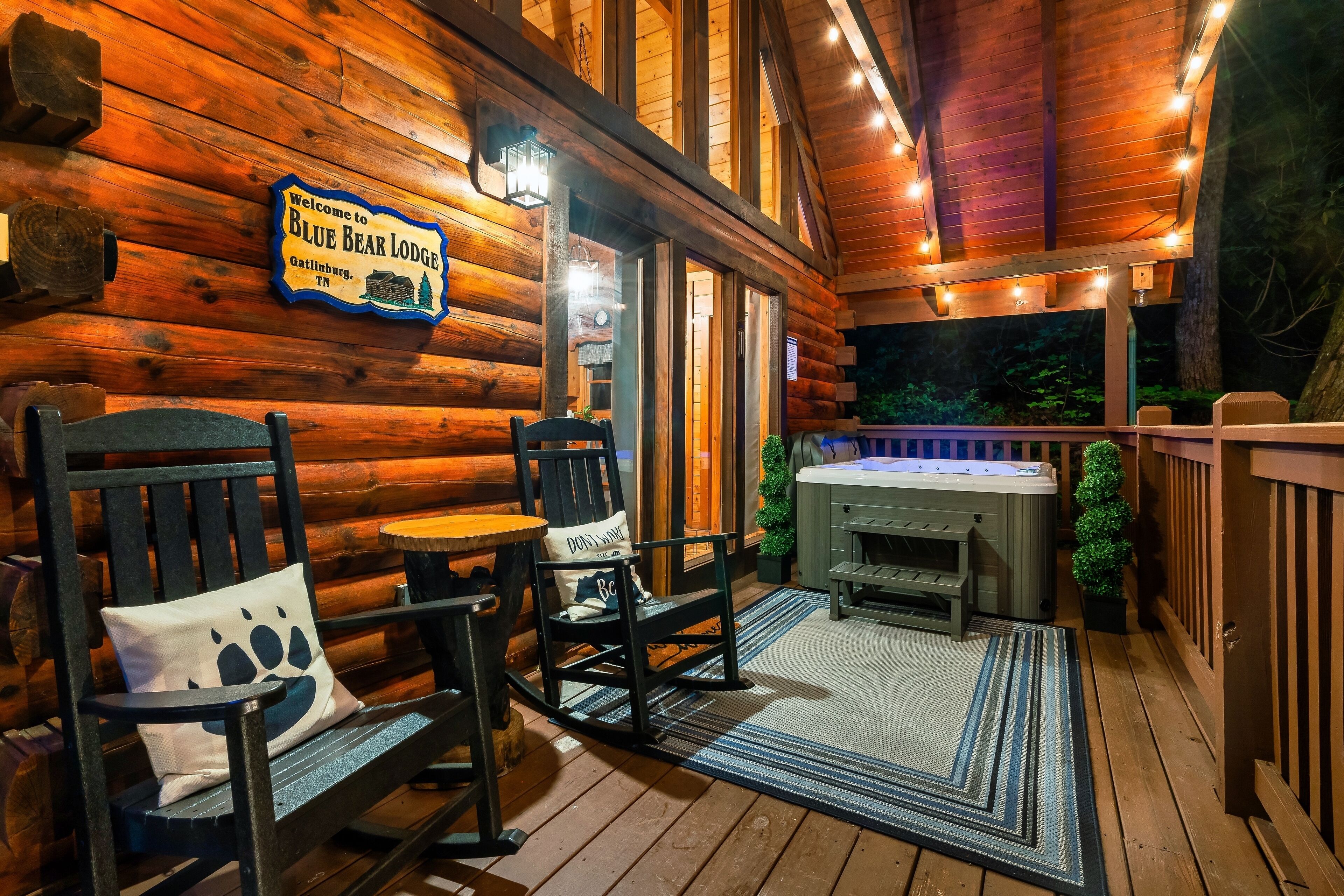 A wooden deck with a sign reading "Welcome to Blue Bear Lodge Gatlinburg, TN."