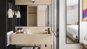 A modern bathroom with a large mirror, a sink, and a towel rack.