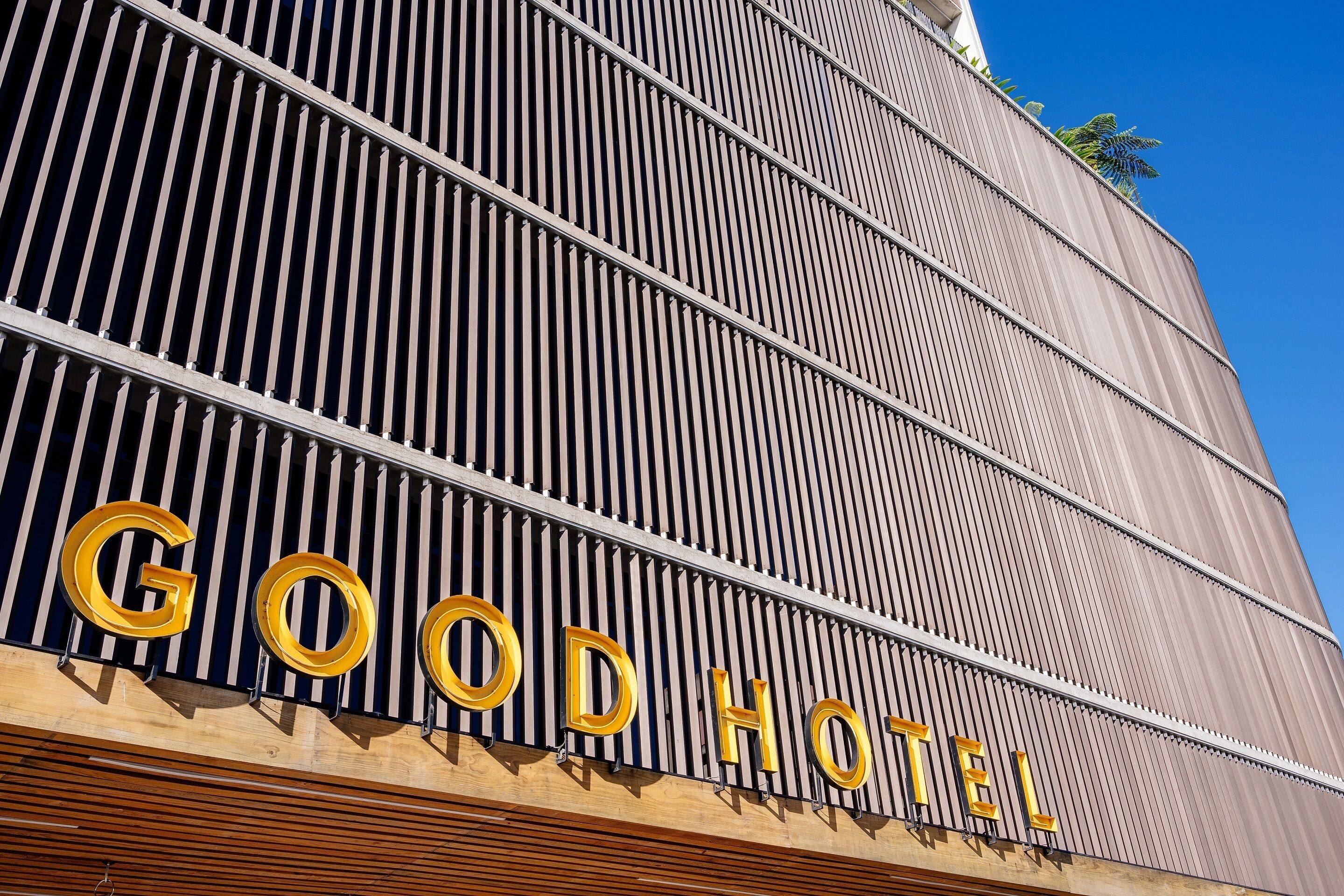 Un edificio con listones verticales y la frase "GOOD HOTEL" en letras grandes.