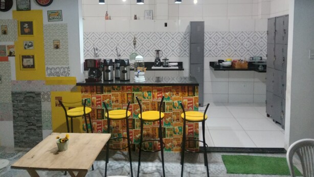 Una cocina con una isla central, taburetes de bar y una mesa de comedor.