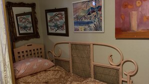 Un dormitorio con una cama, un cabecero y tres cuadros enmarcados en la pared.