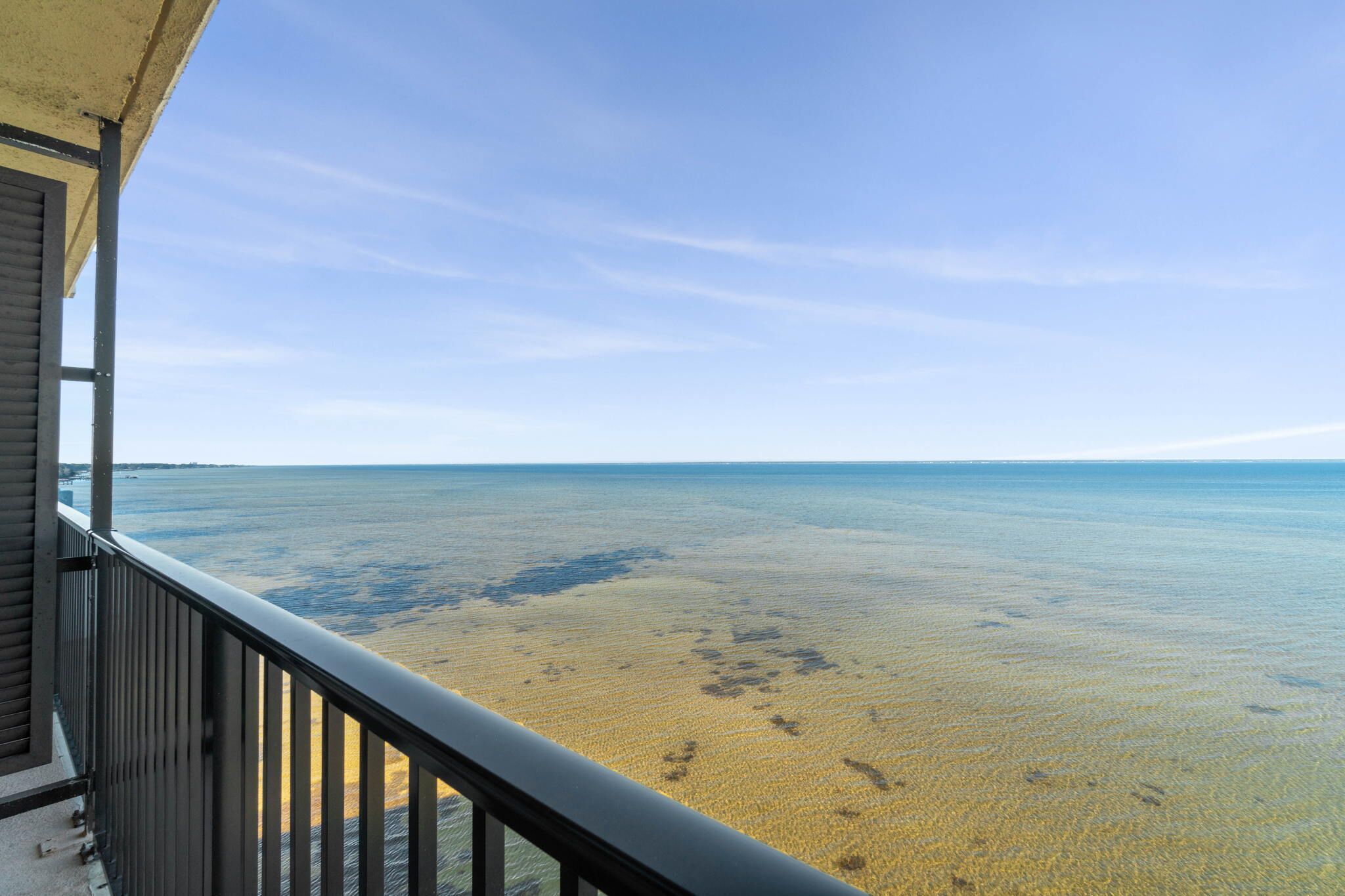 Een balkon met uitzicht op een strand en de oceaan.