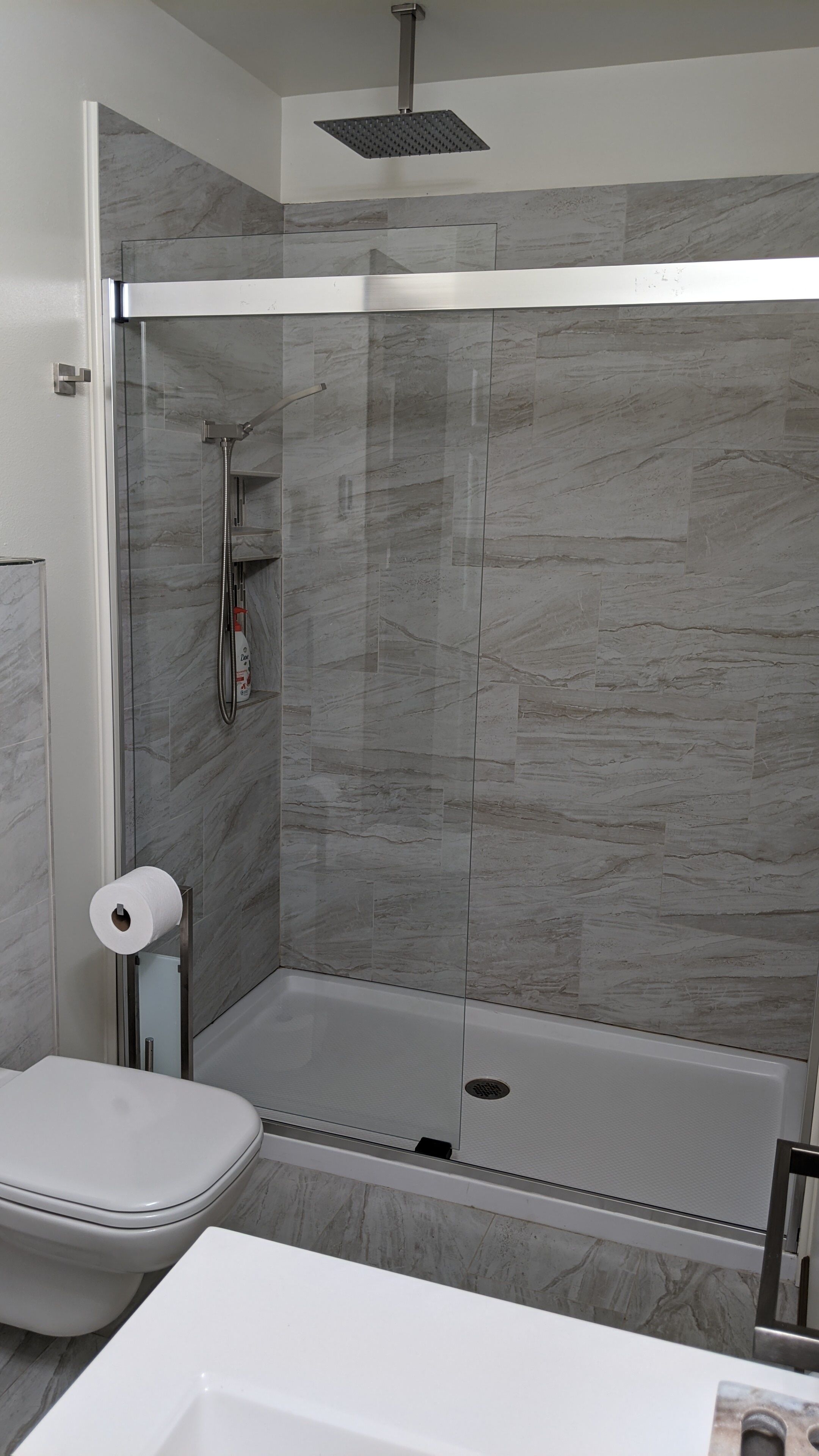 Ein modernes Badezimmer mit einer Duschkabine, einer Toilette und einer Badewanne.