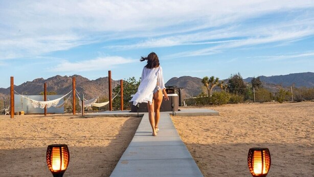A pathway leading to a beach area with hammocks and a desert landscape in the background. - The Magic Hour House | Spa | Pool | Games | Cozy (Joshua Tree)