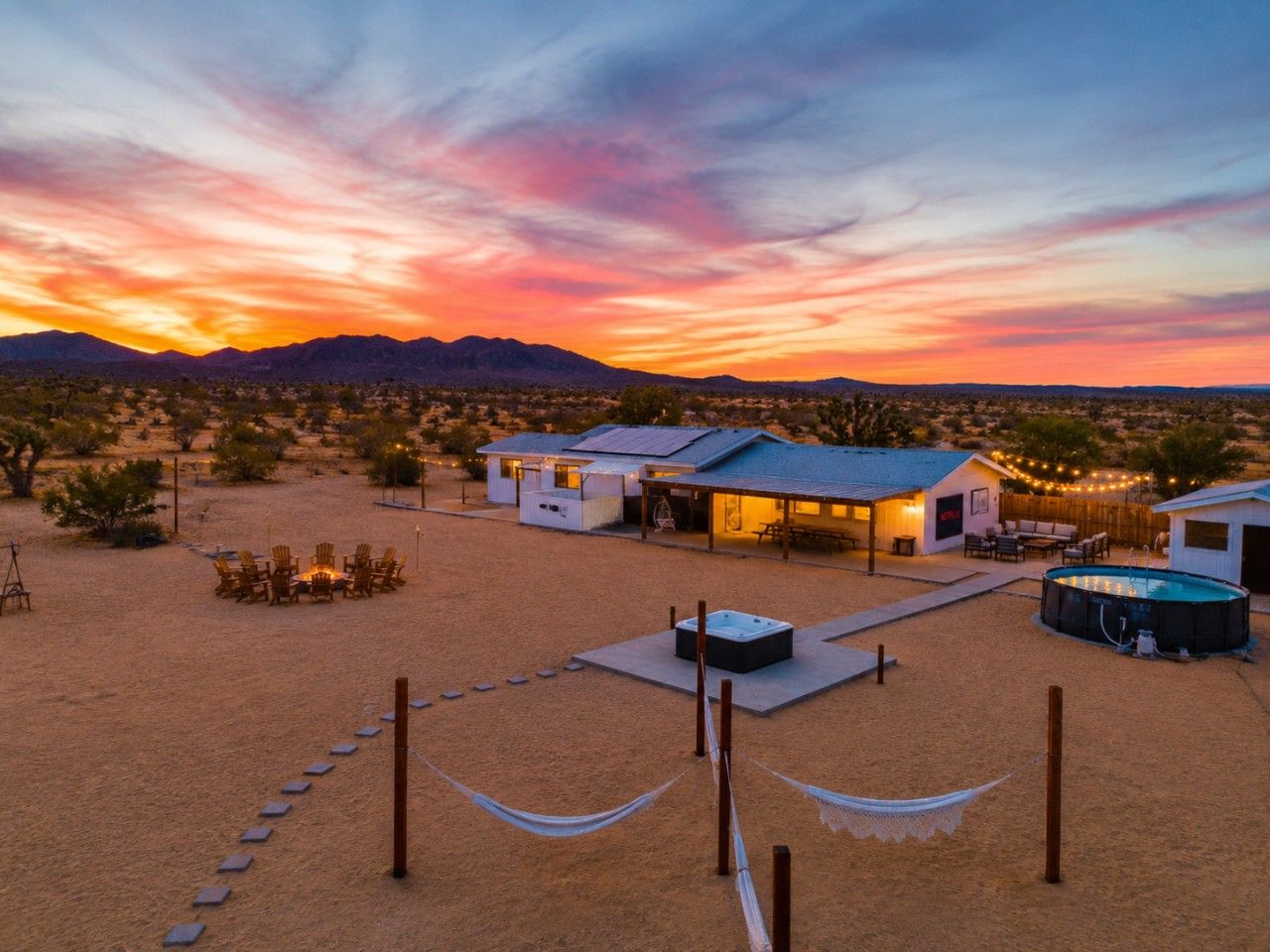 Un resort en el desierto con asientos al aire libre, una bañera de hidromasaje y una piscina.