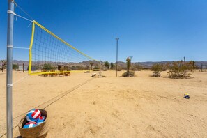 Una rete da pallavolo in un paesaggio desertico sotto un cielo sereno.