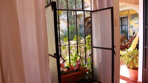 Ein Fenster mit einem Metallgitter und einem Blumentopf.