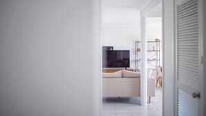 Een moderne woonkamer met een bank, televisie en boekenkasten.