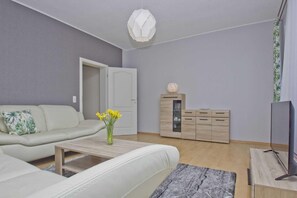 Ein modernes Wohnzimmer mit einer Couch, einem Couchtisch und einer Kommode.