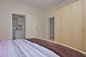Ein Schlafzimmer mit einem Bett, einem Kleiderschrank und einer Tür zu einem Badezimmer.