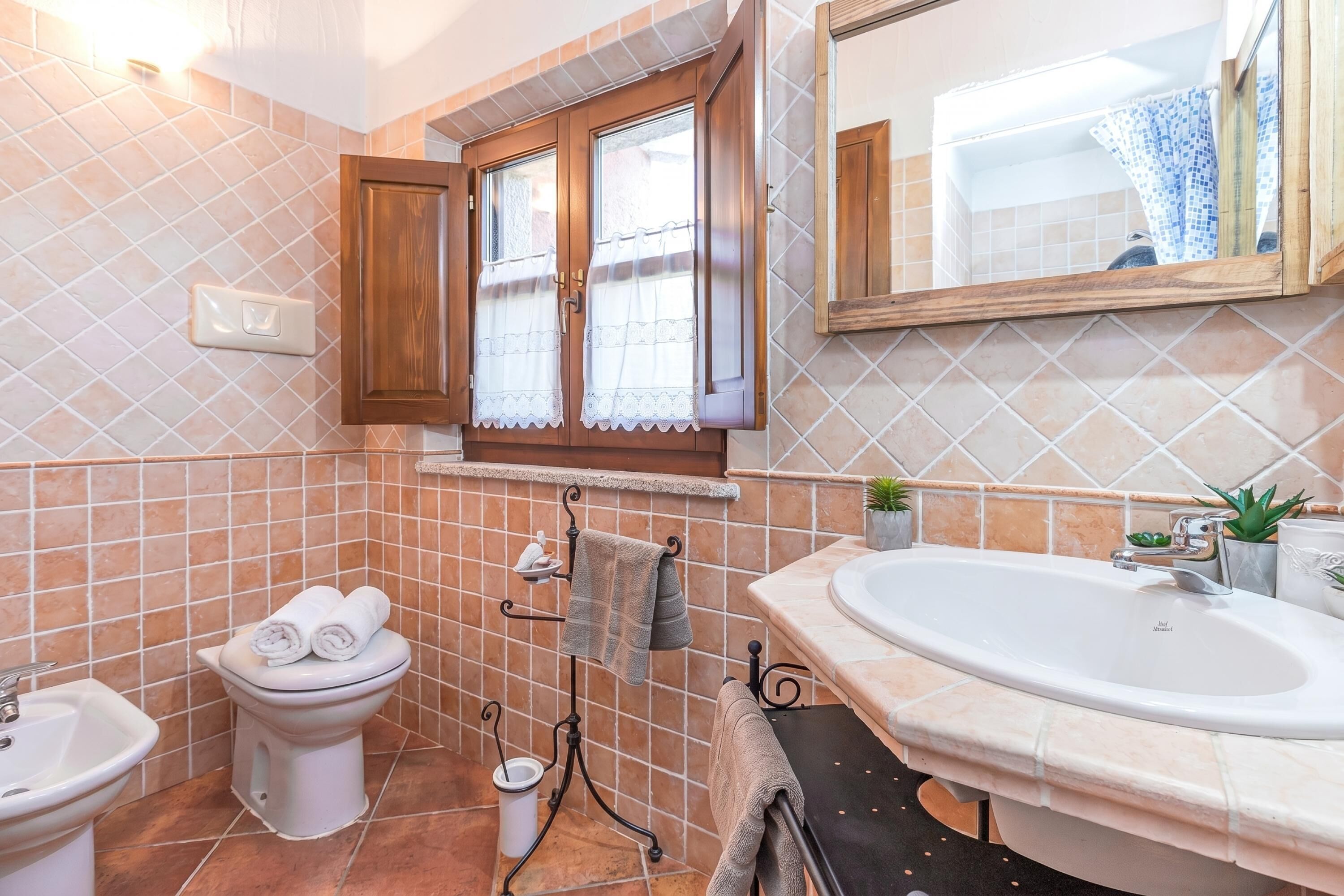 Une salle de bain comprenant des toilettes, un bidet, un lavabo et une baignoire.