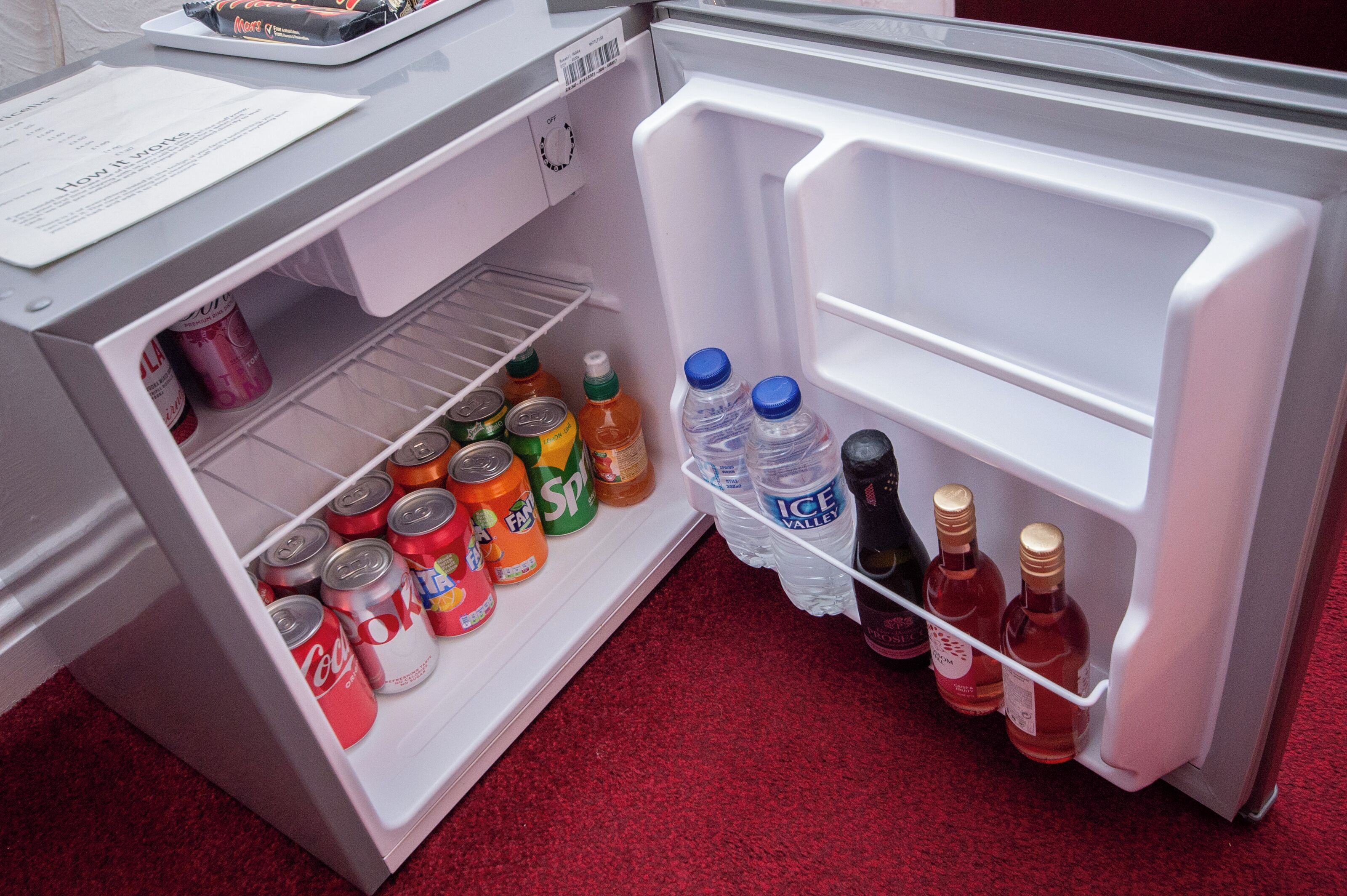 An open refrigerator with various beverages and cans.